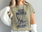 Hermit crab graphic on tan t-shirt with text "JUST MOVED AGAIN."