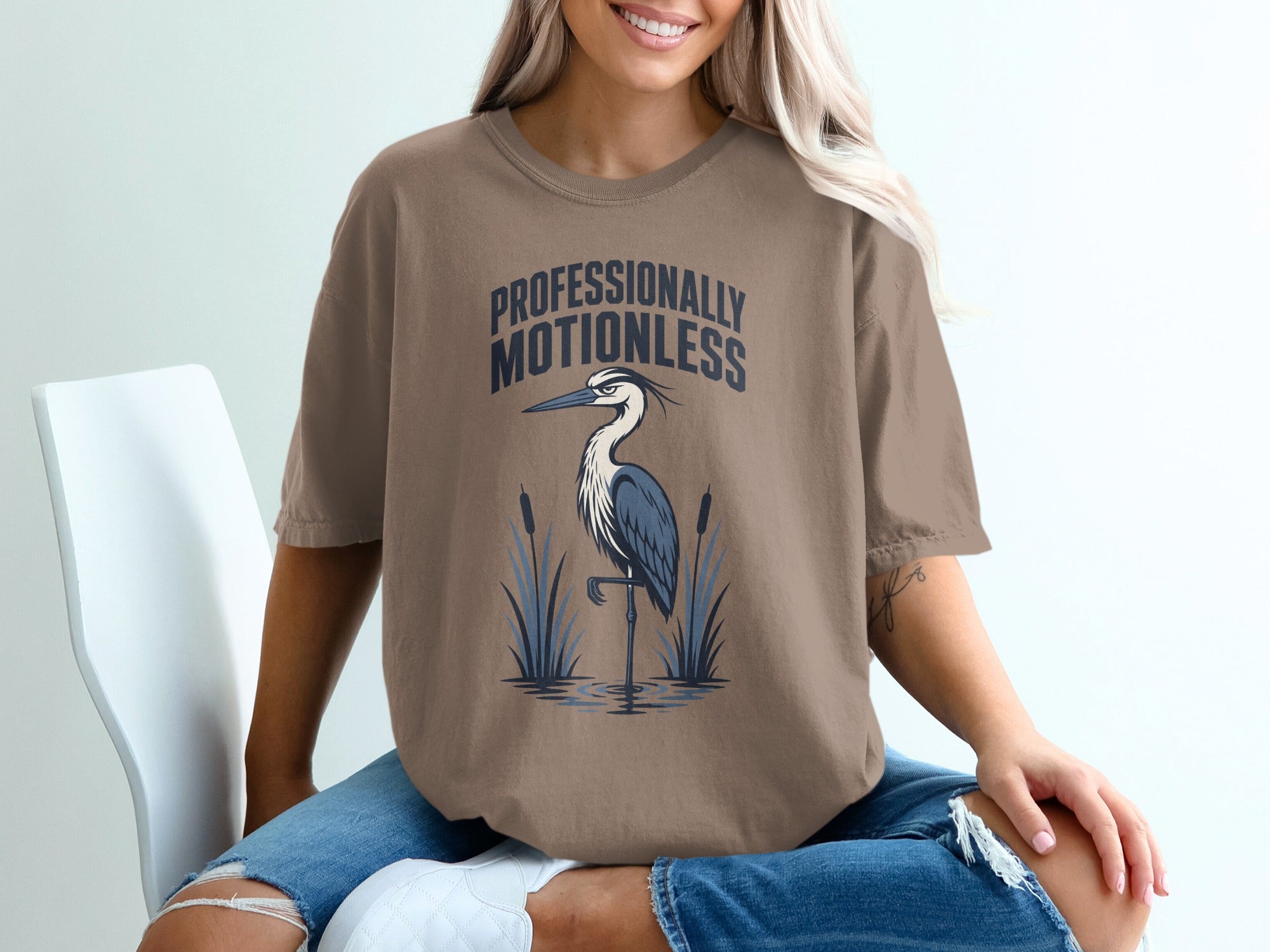 T-shirt with a heron graphic and text "PROFESSIONALLY MOTIONLESS".
