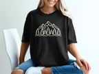 Black t-shirt with a line-art design of mountains and pine trees.