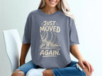 Grey t-shirt with a graphic of a hermit crab and text that reads "JUST MOVED AGAIN."