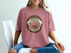 T-shirt with "Survived an adult conversation" merit badge design.