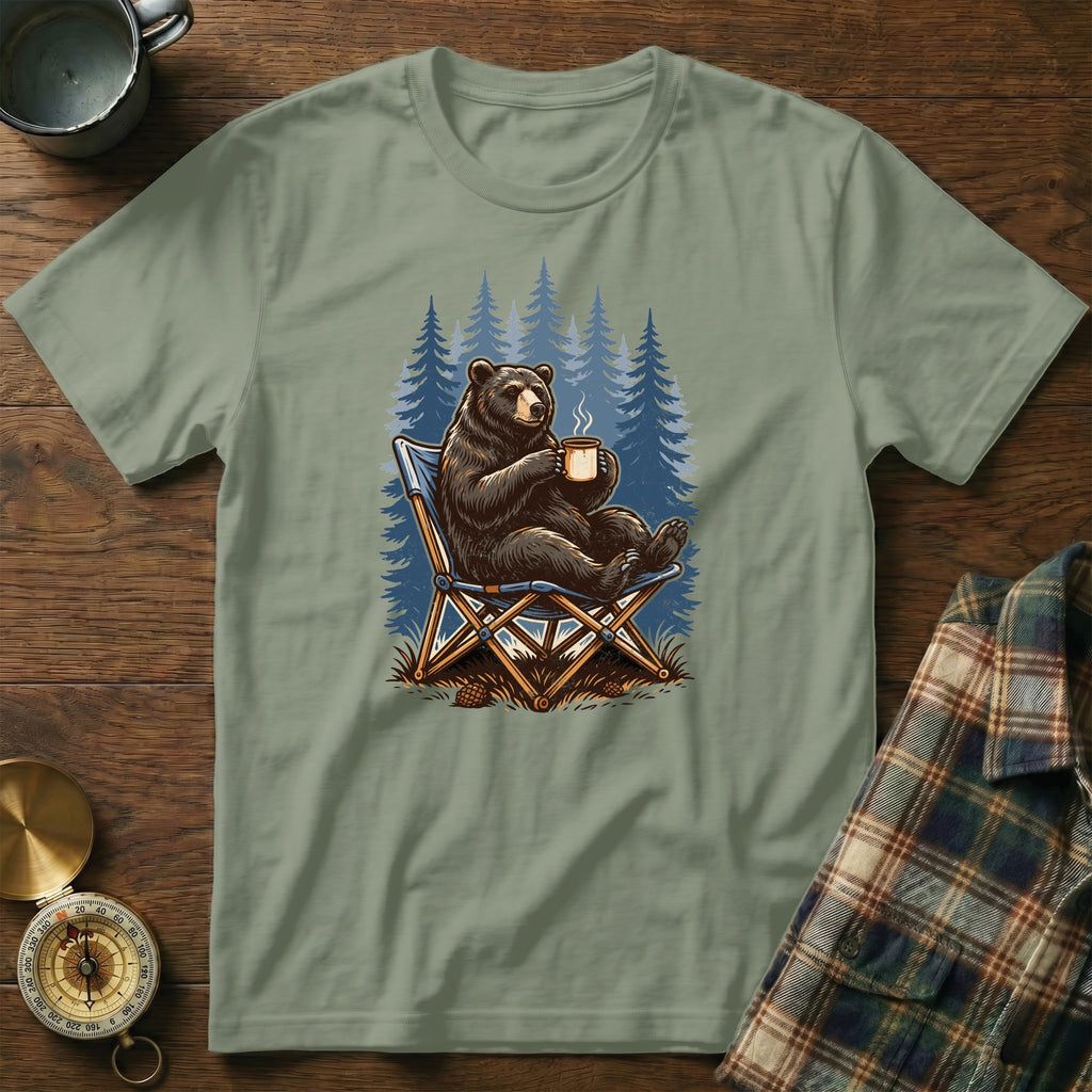 Bear in camping chair with coffee mug in front of pine trees illustration.