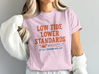 Pink t-shirt with "Low Tide Lower Standards" and a crab graphic.