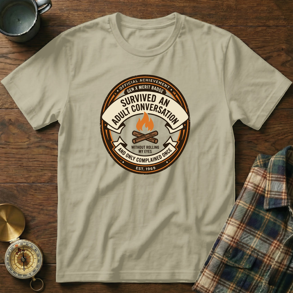 Cream t-shirt with a circular badge graphic about surviving adult conversation.
