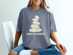 Grey t-shirt with stacked stones and "BALANCE IS OVERRATED" text.