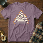 Purple t-shirt with abstract mountain logo, beside a plaid shirt and compass.
