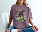 Purple t-shirt with whale breaching ocean waves graphic design.