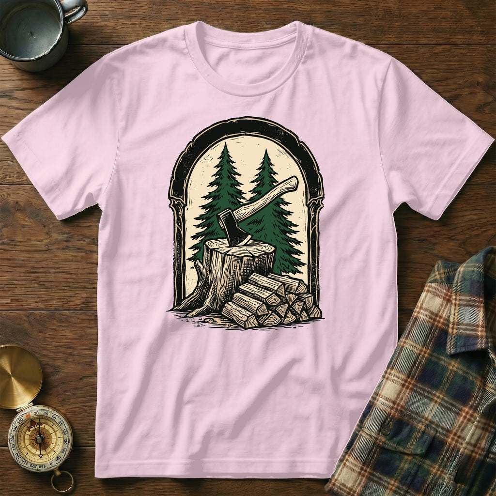 Pink t-shirt with forest scene: axe in stump, firewood, and pine trees.