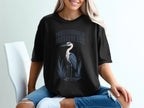 Black t-shirt with "Professionally Motionless" text and a heron graphic.