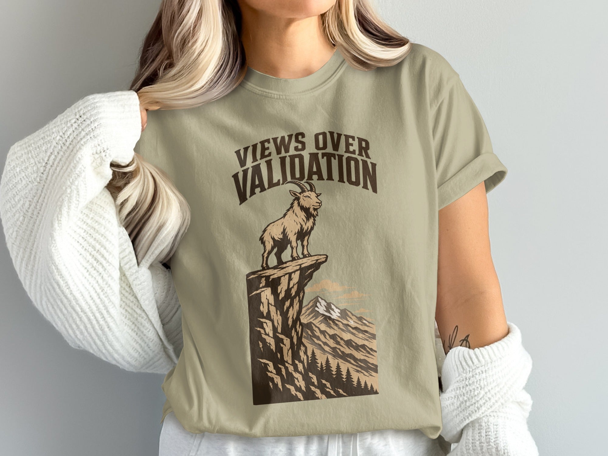 T-shirt graphic with goat on cliff and text "Views Over Validation."