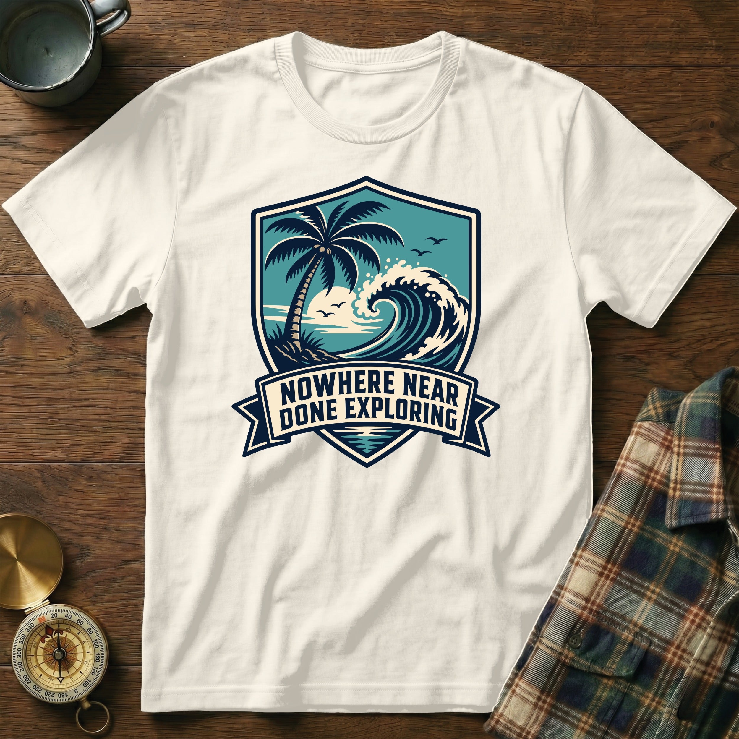 White t-shirt with blue beach graphic and "NOWHERE NEAR DONE EXPLORING" text.