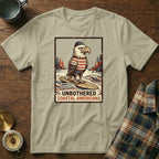T-shirt with distressed graphic of bald eagle surfing, text "Unbothered Coastal Americana".
