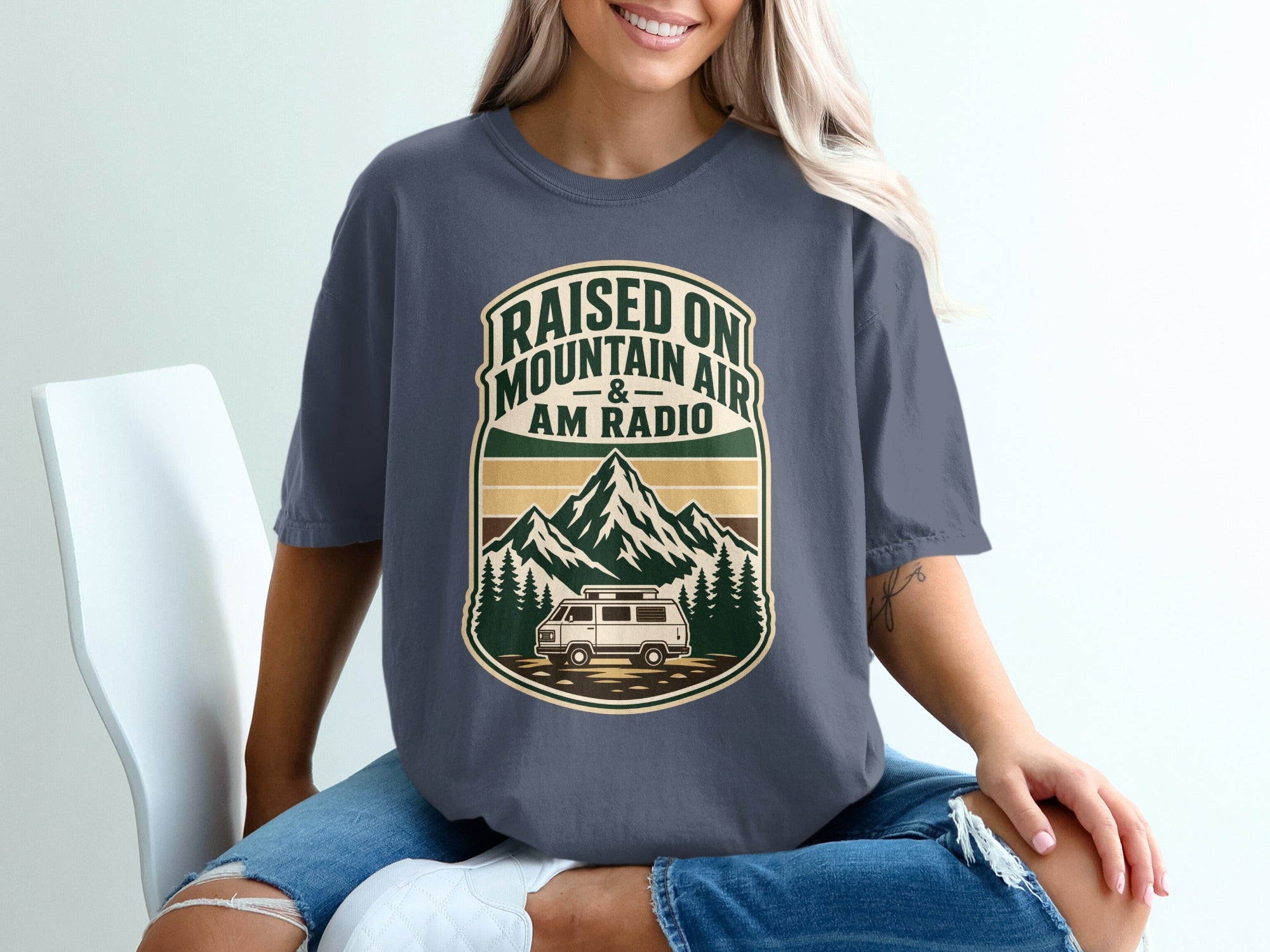 Graphic t-shirt with Mountains, van, trees, and text "Raised on Mountain Air & AM Radio."