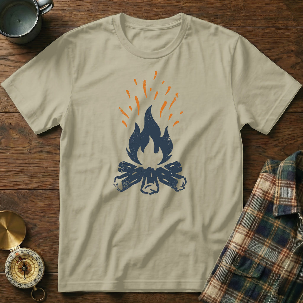 Tan t-shirt with stylized blue campfire and orange sparks graphic.