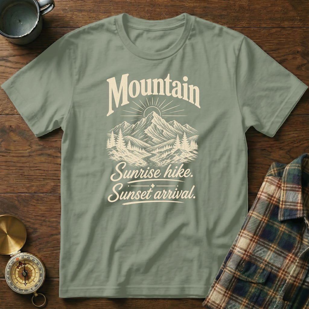 Sage green t-shirt featuring a mountain and forest graphic with the text Mountain Sunrise hike Sunset arrival.