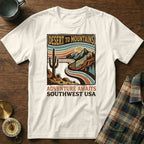 White t-shirt graphic with desert mountain landscape and text "DESERT TO MOUNTAINS ADVENTURE AWAITS SOUTHWEST USA".
