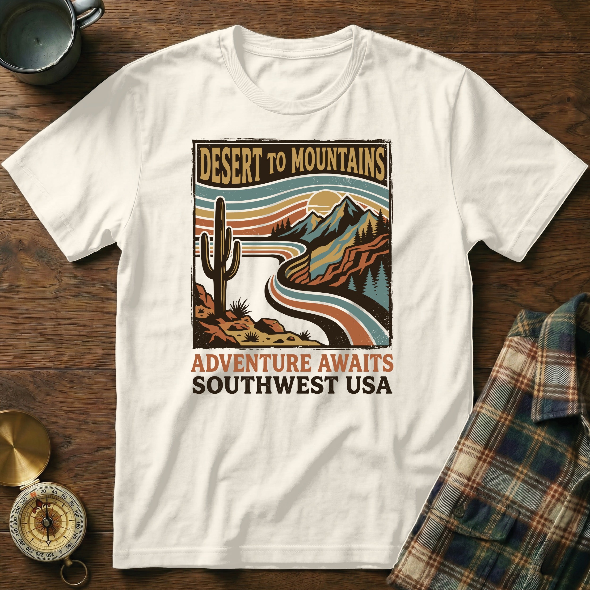 White t-shirt graphic with desert mountain landscape and text "DESERT TO MOUNTAINS ADVENTURE AWAITS SOUTHWEST USA".