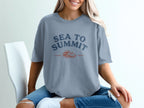 Gray t-shirt with "Sea to Summit" text and ocean wave and mountain graphic.