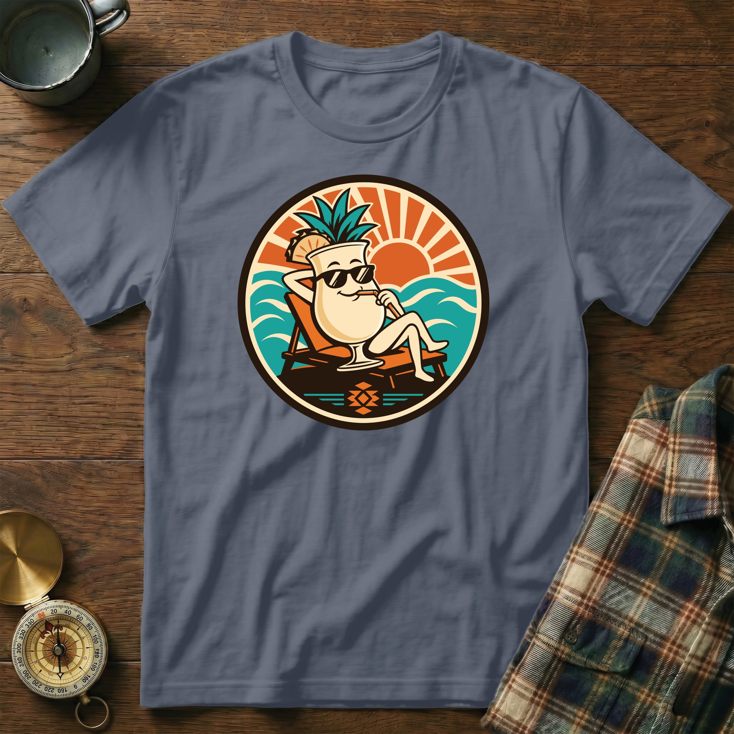 T-shirt graphic of a cartoon cocktail on a lounge chair at the beach.