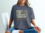 Gray t-shirt with "Built for Uneven Terrain" text and mountain graphic.