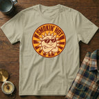 Light tan t-shirt with a circular graphic of a smiling sun wearing sunglasses.