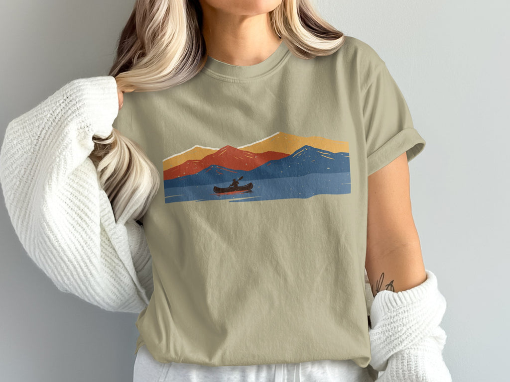 T-shirt with a retro abstract mountain landscape and a single canoe on the water.
