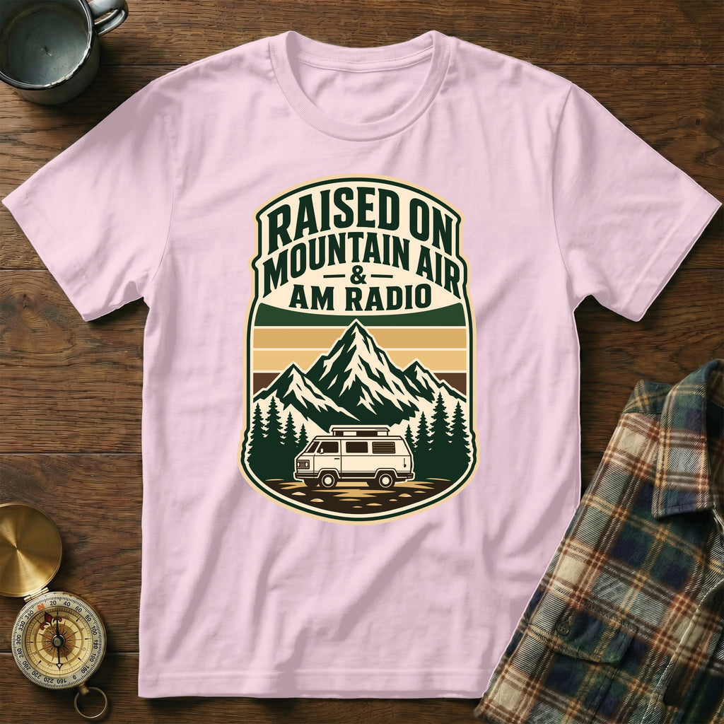 Pink t-shirt with graphic "Raised on Mountain Air & AM Radio" and mountains/van scene.