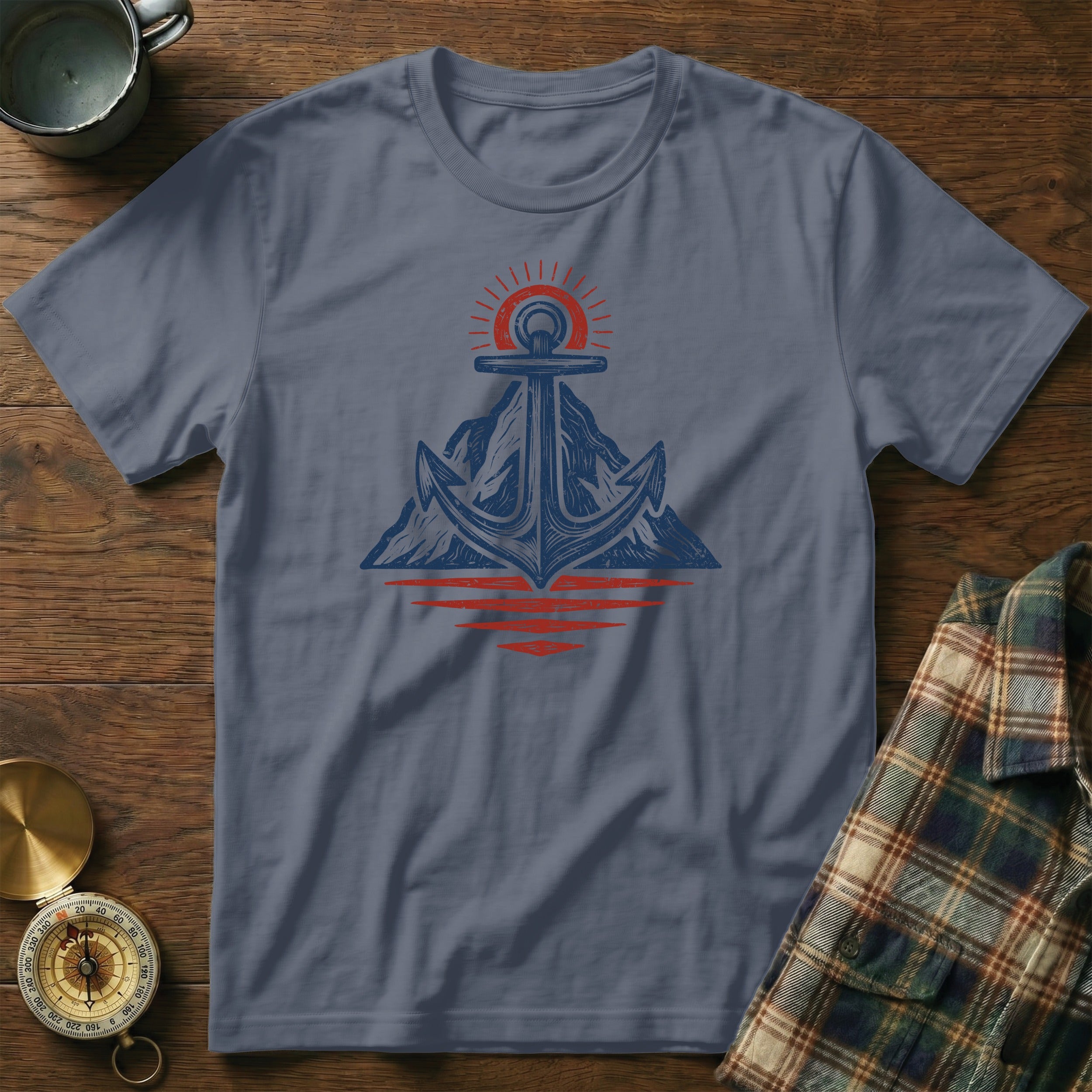 Anchor and sun over mountains reflecting on water graphic on t-shirt.