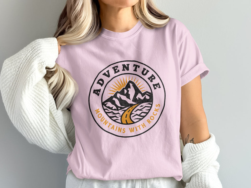 Pink t-shirt with circular "Adventure Mountains with Rocks" graphic.