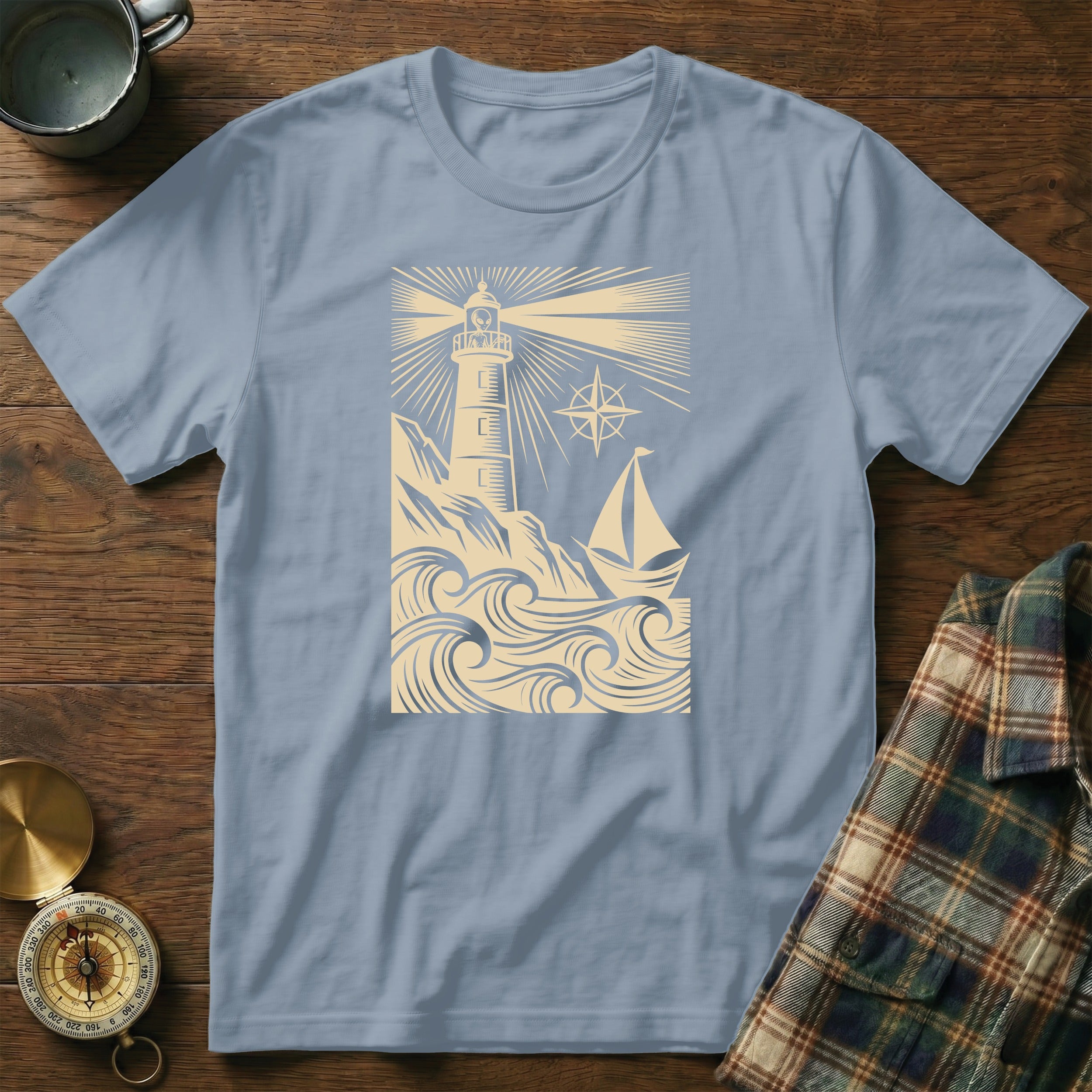 Light blue t-shirt with lighthouse, sailboat, and waves design.