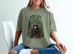Green t-shirt with a sitting bear and "Den Life Do Not Disturb" text.