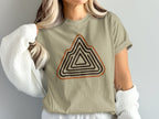 Tan t-shirt with geometric mountain range graphic in brown and orange stripes.