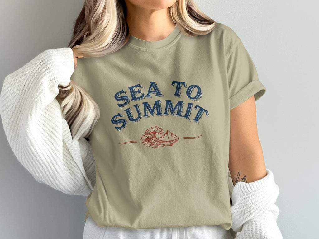 Sand t-shirt with blue "SEA TO SUMMIT" text and a wave and mountain graphic.