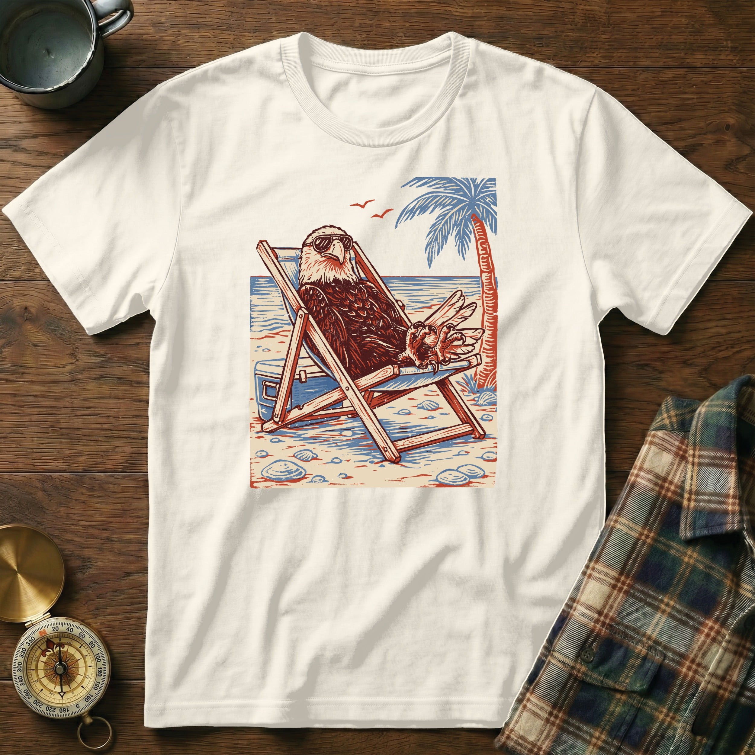 Graphic tee featuring an eagle relaxing in a beach chair with sunglasses.