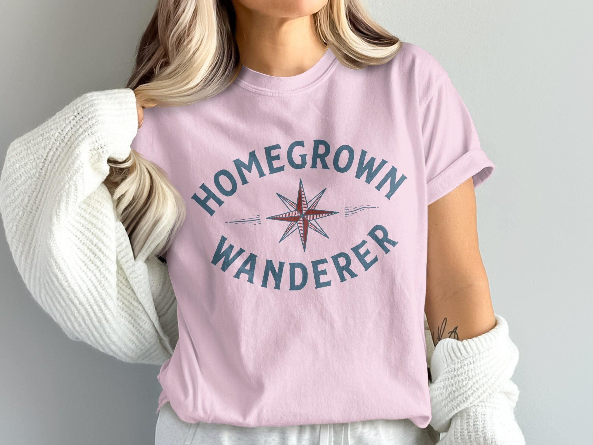 Pink t-shirt with "HOMEGROWN WANDERER" text and compass graphic.