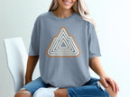 Blue t-shirt with a geometric mountain design in orange and cream stripes.
