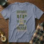 Slate blue crewneck t-shirt featuring the green and gold text HURRY UP AND WAIT with an hourglass graphic.