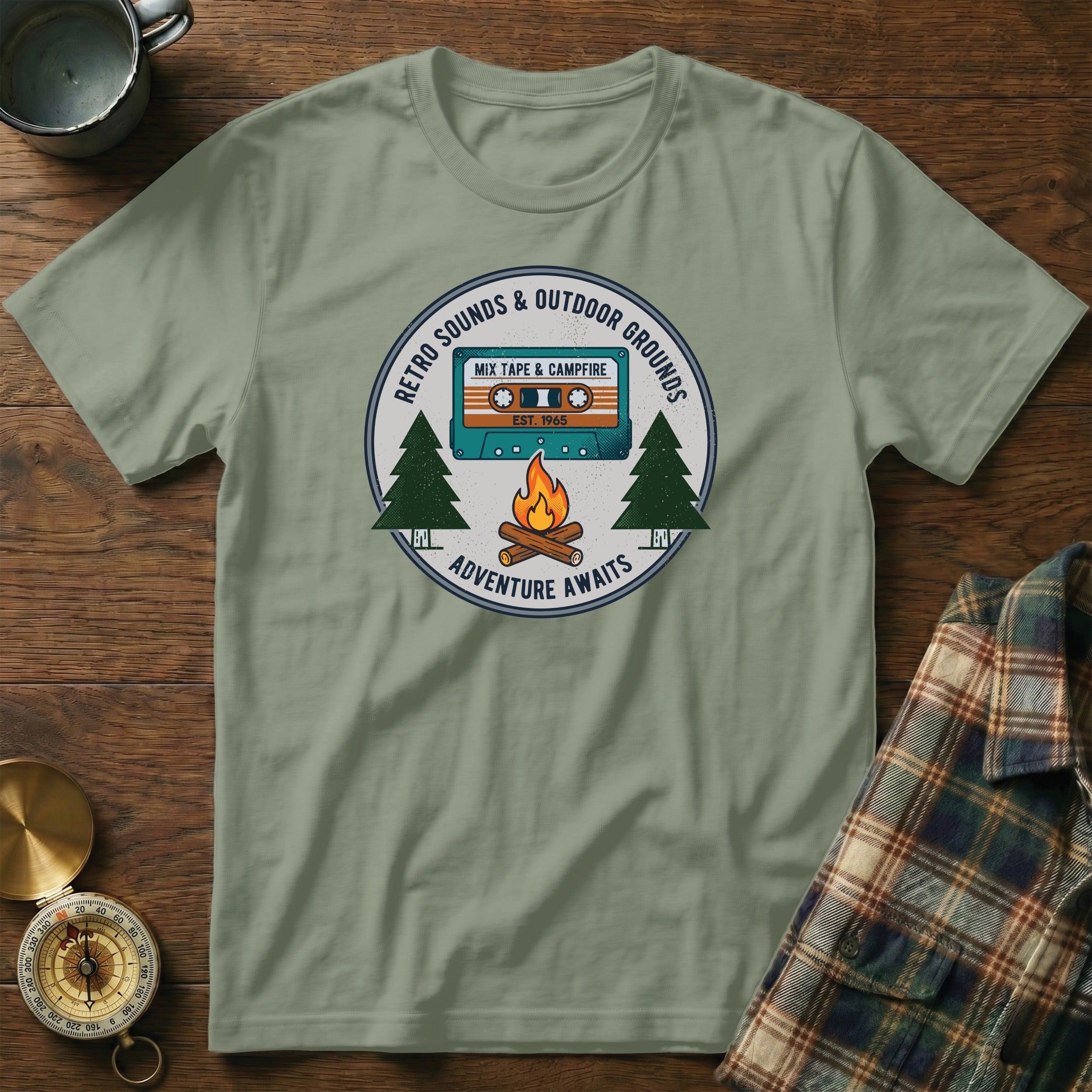 Retro "Adventure Awaits" t-shirt graphic with cassette, campfire, and trees.