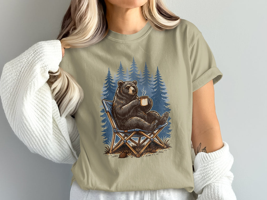 Bear sitting in a camping chair with a mug in a forest.