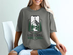 T-shirt graphic with phone displaying mountain landscape, "Less Scroll. More Stroll."