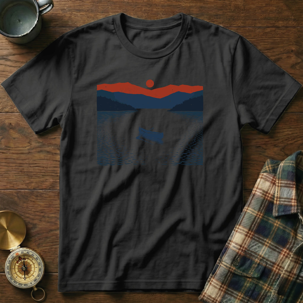 Black t-shirt with a minimalist landscape graphic of a boat on a lake at sunset.