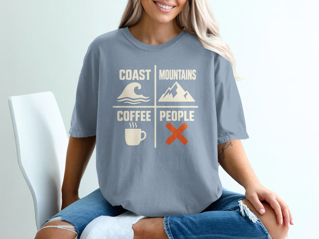 Shirt with "Coast Mountains Coffee People" graphic featuring wave, mountain, coffee cup, and X icons.