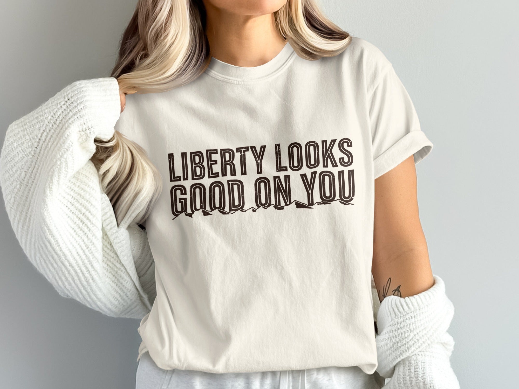 White t-shirt with brown text "LIBERTY LOOKS GOOD ON YOU"