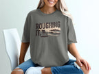 Gray t-shirt with "ROUGHING IT." text, beach scene with chair and waves.