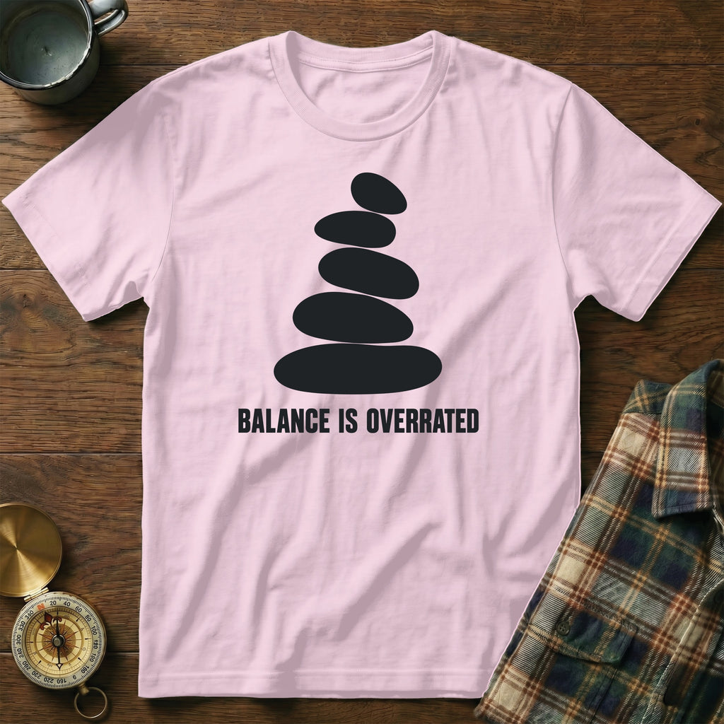 Pink t-shirt with black stacked stones graphic and "BALANCE IS OVERRATED" text.