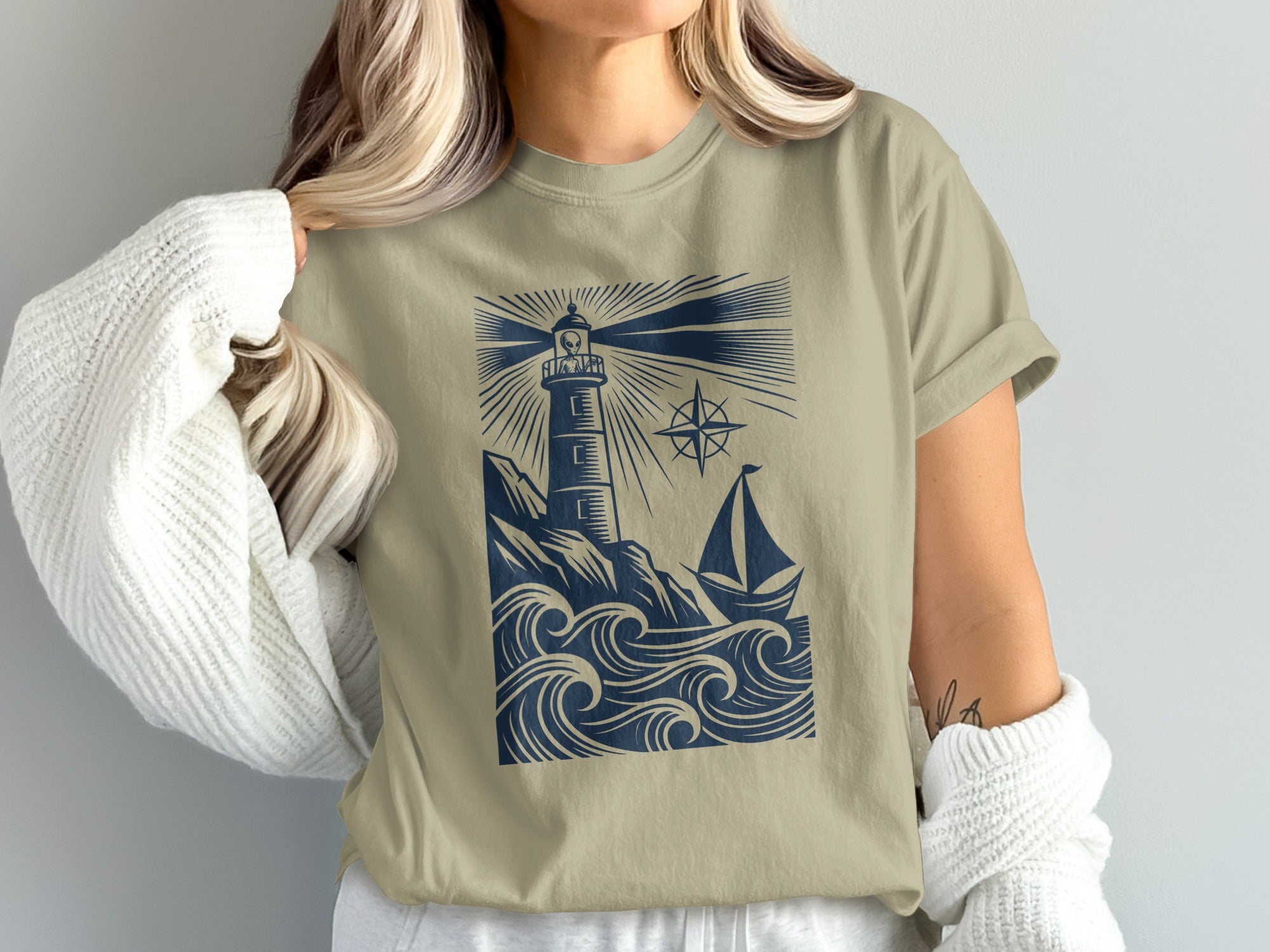 T-shirt with lighthouse, sailboat, and choppy waves graphic.